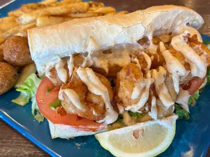 Fried shrimp po' boy with fries and hush puppies